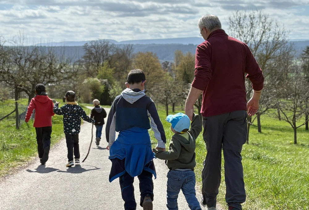 Erzieher mit einer gruppe Kindern draußen unterwegs