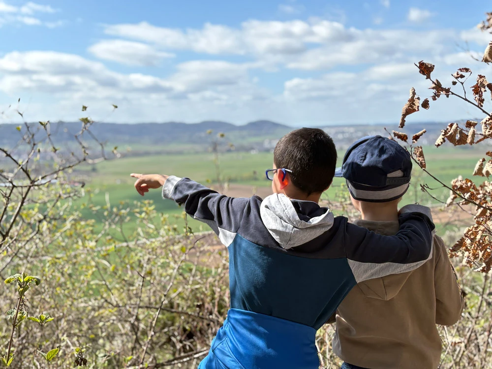 Two boys, arm in arm, are looking into the distance
