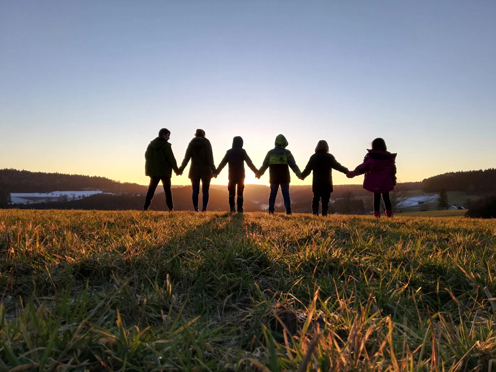 Kinder halten sich im sonnenuntergang an den Händen
