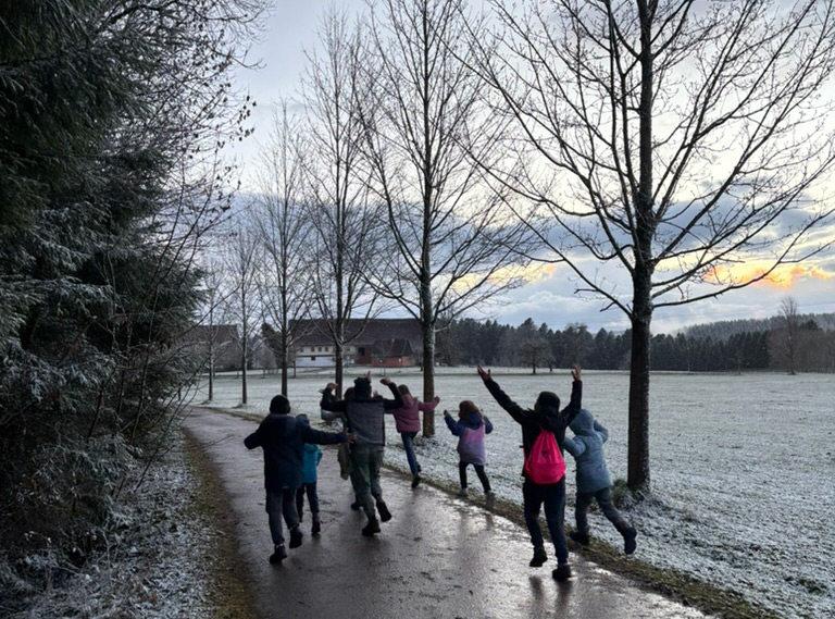 Kinder laufen einen winterlichen Feldweg entlang